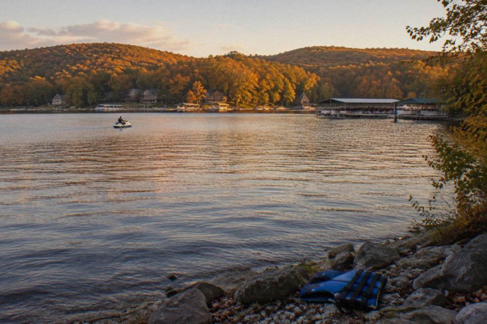 Open water on a mountain lake in late afternoon light with tree-covered ridges along the far shore