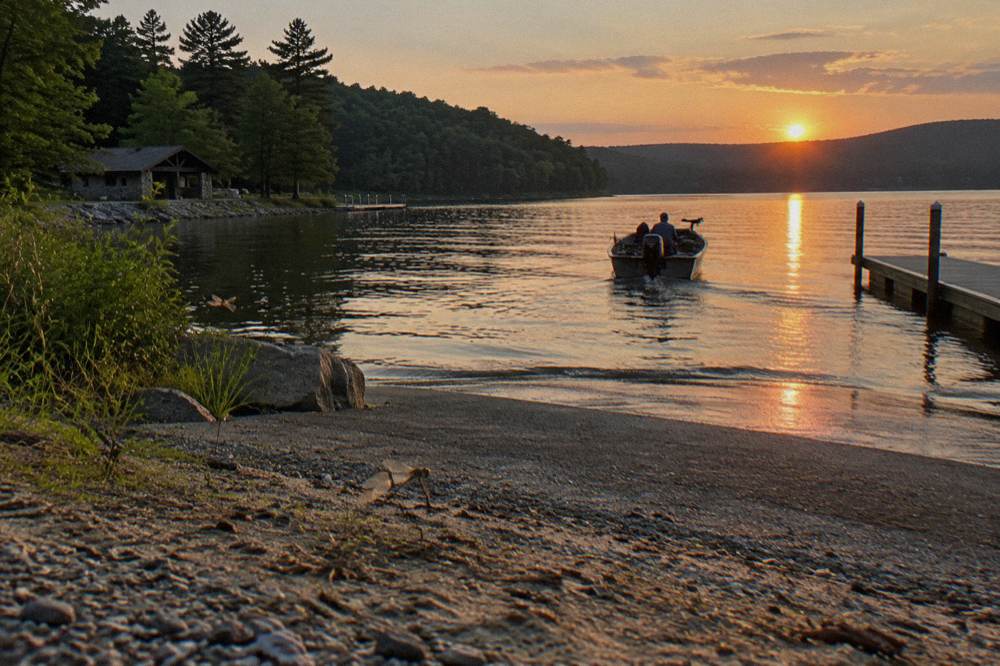 Sunset over Deep Creek Lake with a fishing boat returning toward a boat ramp