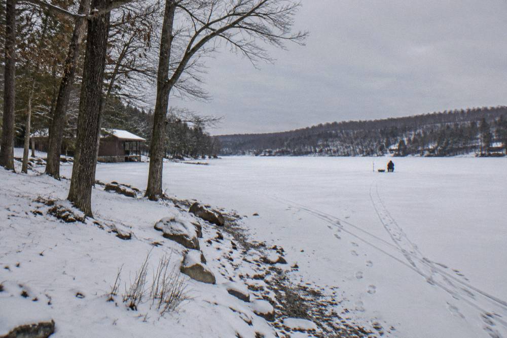 Snow covered state park shoreline leading onto a broad frozen lake