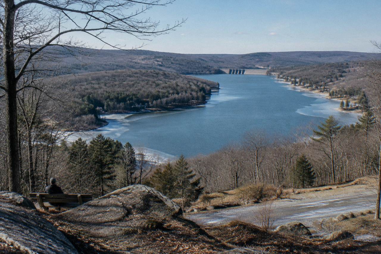 Wide view across a mountain lake with forested ridges and a long stretch of open water