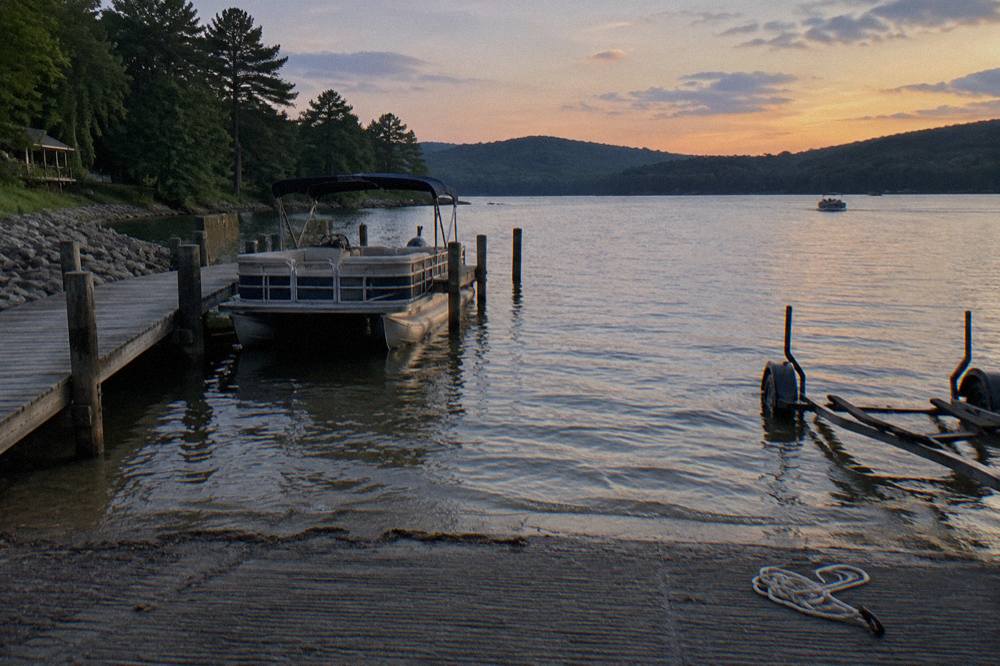 Public boat launch ramp at a lake state park with a pontoon boat tied at a dock
