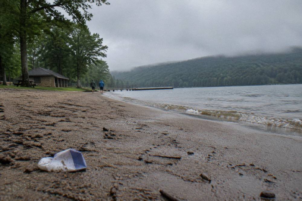 Sandy swimming beach beside a mountain lake with a forested shoreline