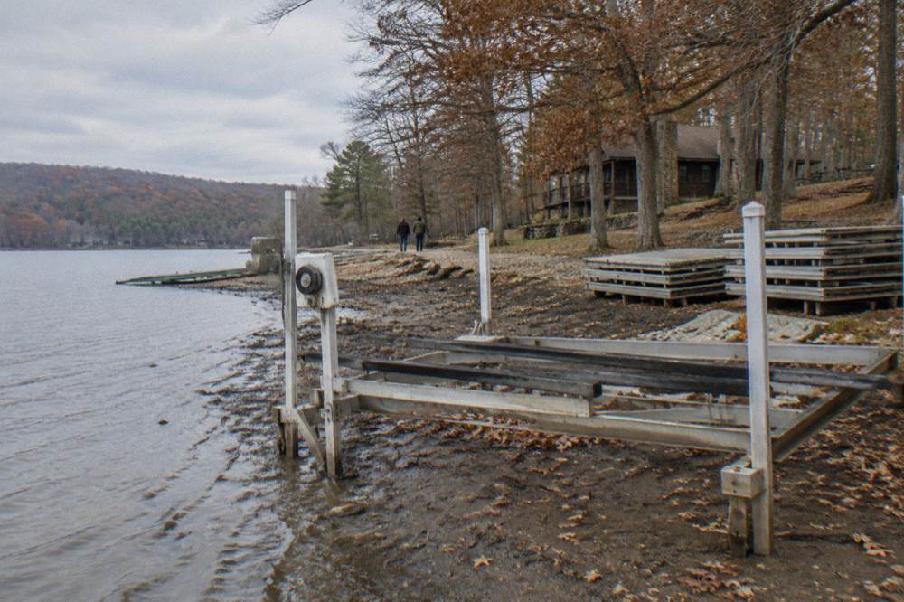 Empty boat lift and dock on a calm lake shoreline in autumn