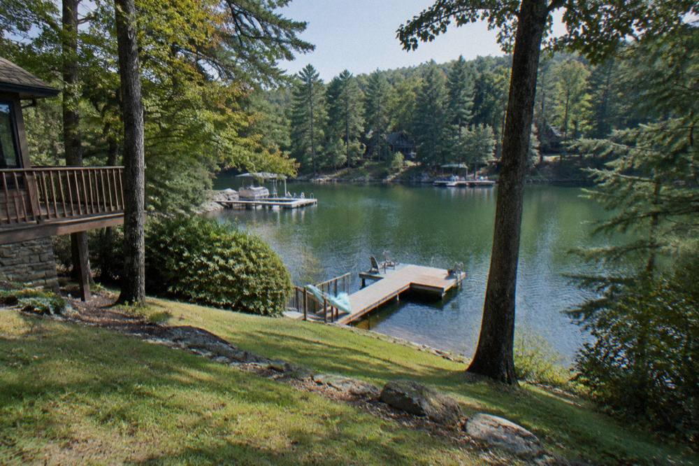 Wooded shoreline of a mountain lake with private wooden docks extending over calm water