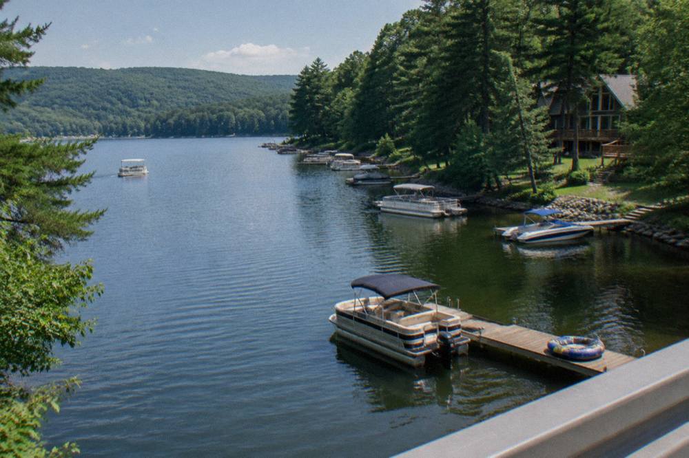 Boats anchored in a quiet cove with forested hills behind them