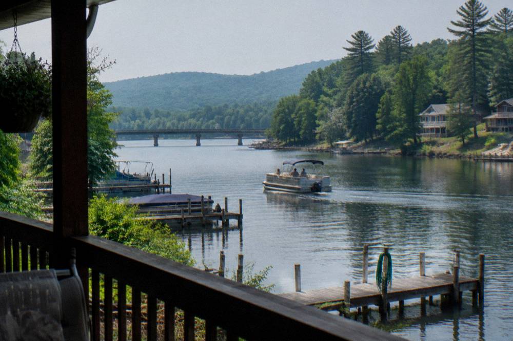 Idle pontoon boat passing a line of private docks along the shoreline