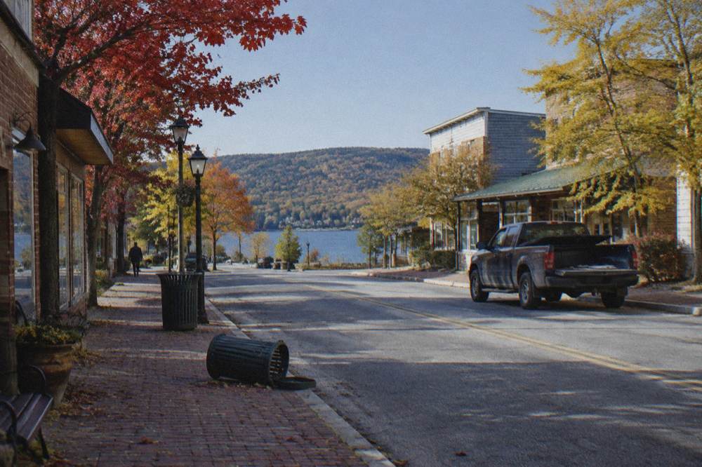 Small town main street lined with autumn trees under a clear sky