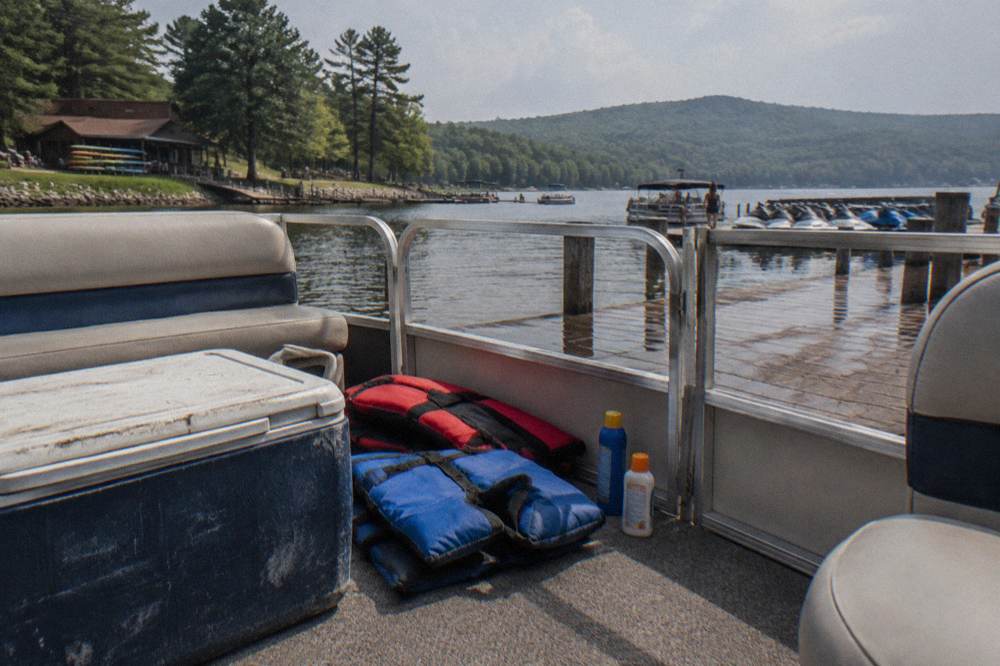 Cooler, life jackets and supplies staged on a pontoon boat deck