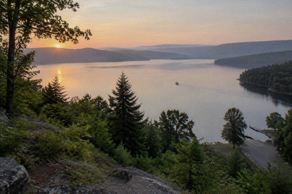 A wide view of Deep Creek Lake's main basin with tree covered ridges on both shores