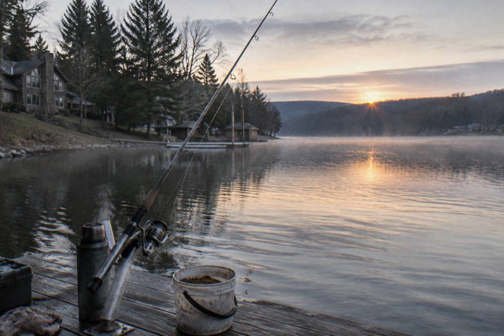 Fishing rod resting in a rod holder on a dock at first light