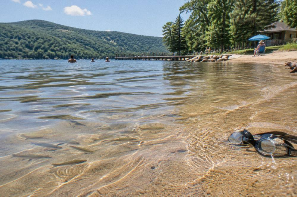Gentle shallow water over sand at a lake beach edge with mountains in the distance