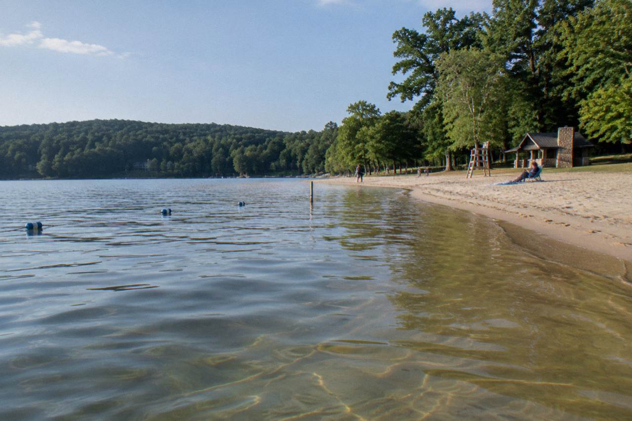 Sandy shoreline and calm lake water at a Deep Creek Lake swim beach