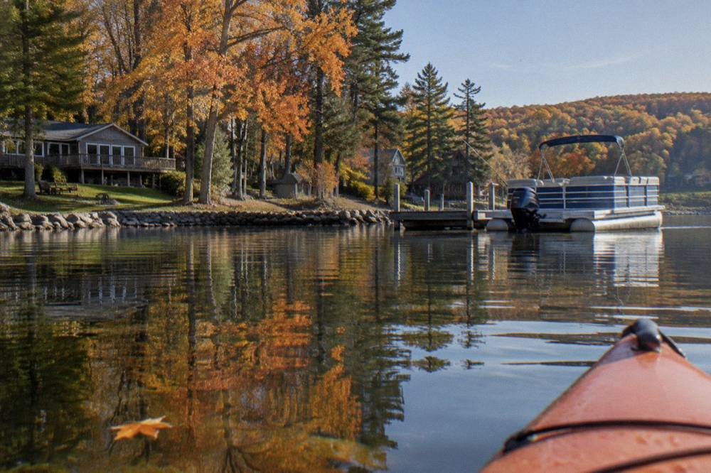 Autumn trees in orange and gold reflected in still lake water