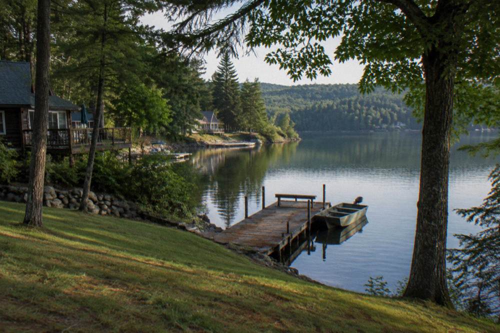 Quiet tree-lined cove with still water reflecting the shoreline at the south end of a lake